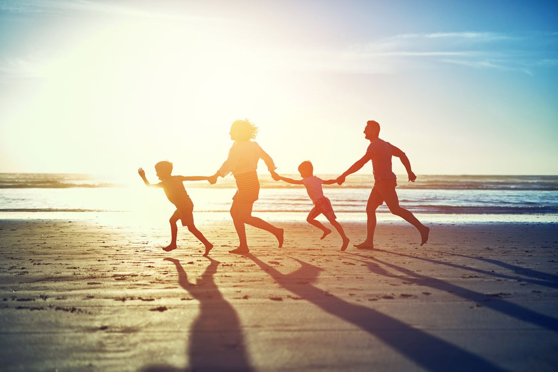 family in silhouette on beach